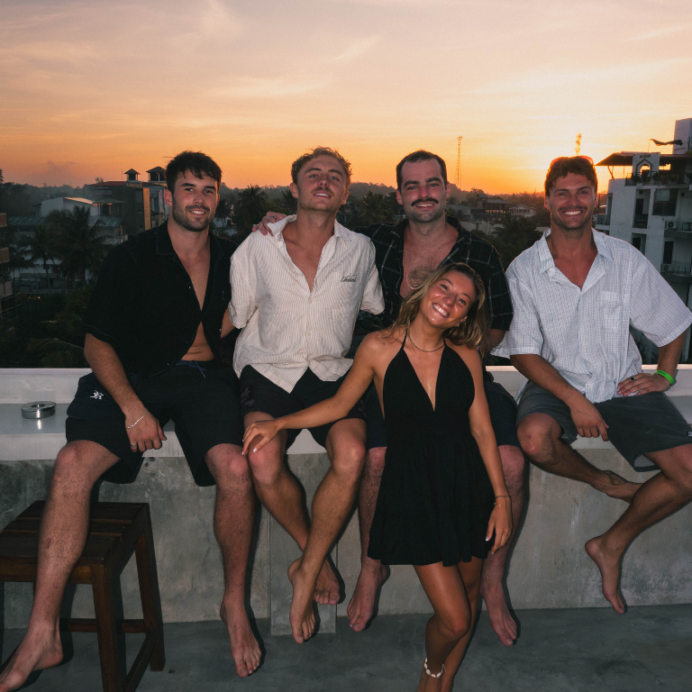 New friends watching the sunset together during a solo surf trip in Bali